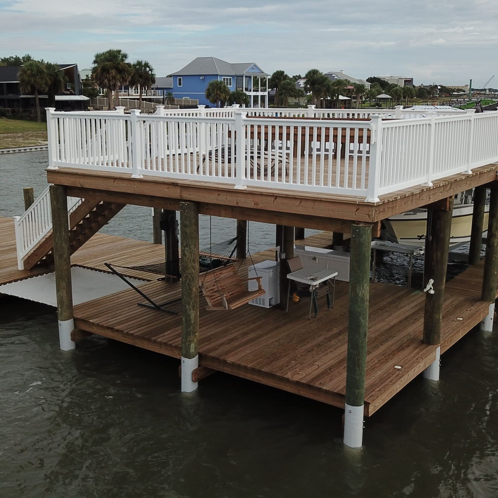 Custom upper sundeck with vinyl railings over a covered slip